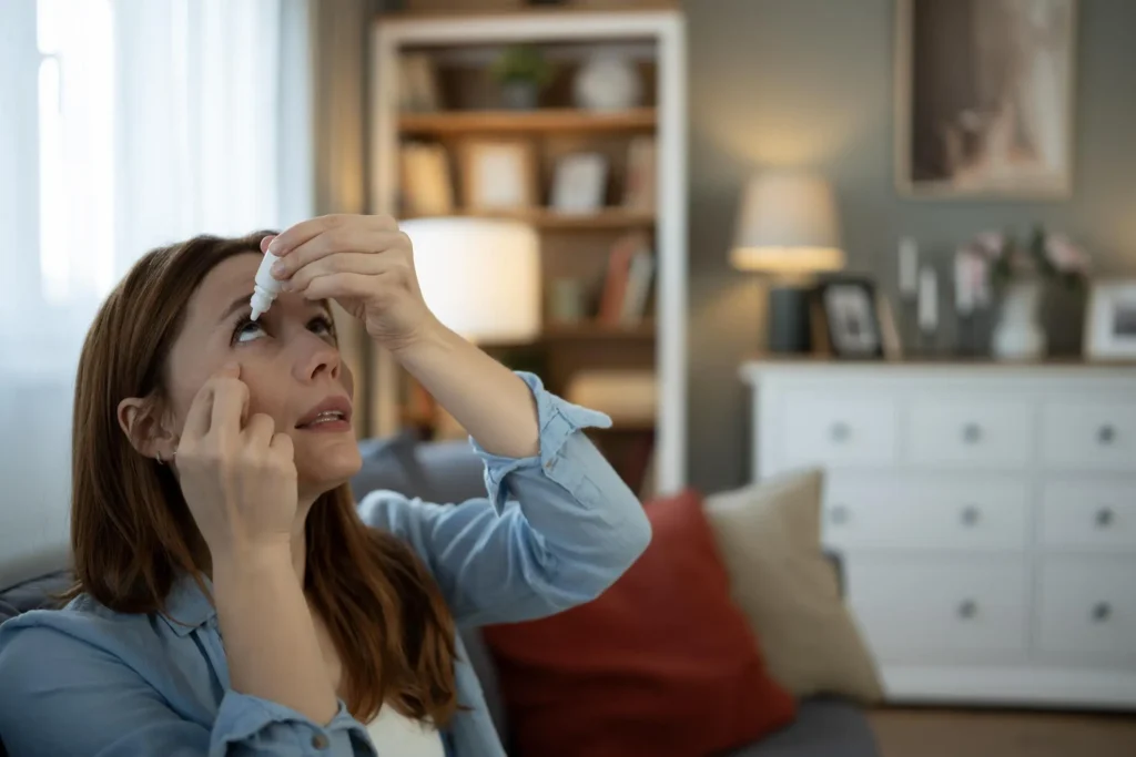 Red Eyes Causes: Why Your Eyes Turn Red and What to Do About It woman applying eye drops for dry eye relief at home
